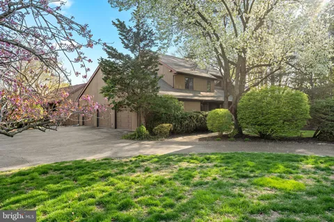 a front view of a house with a yard and tree s