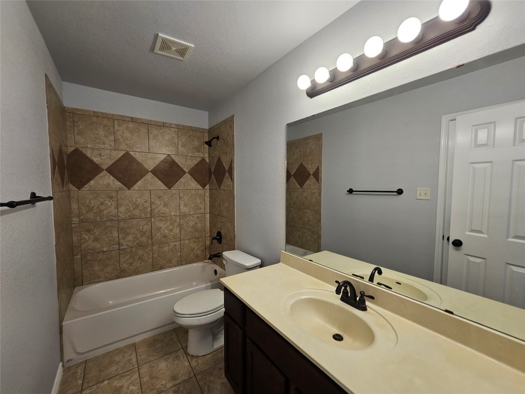 154 Sierra Rose Loop Georgetown, TX 78626 - Photo 5 of 13 a bathroom with a toilet a sink a mirror a bathtub and shower