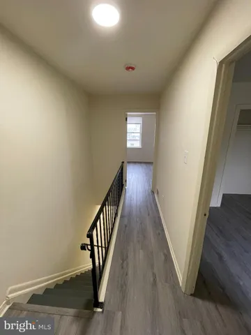 a view of a hallway with wooden floor and staircase