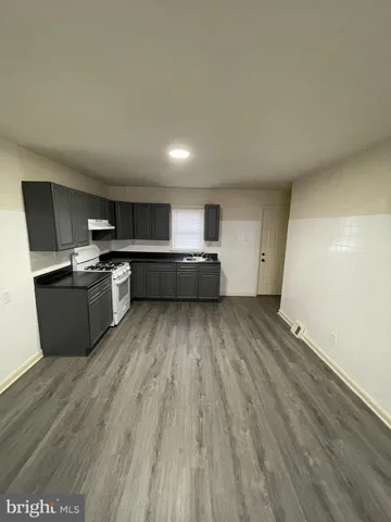 a view of kitchen with wooden floor and electronic appliances