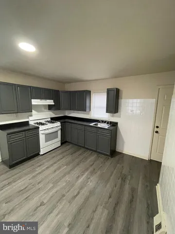 a large kitchen with a stove top oven sink and cabinets