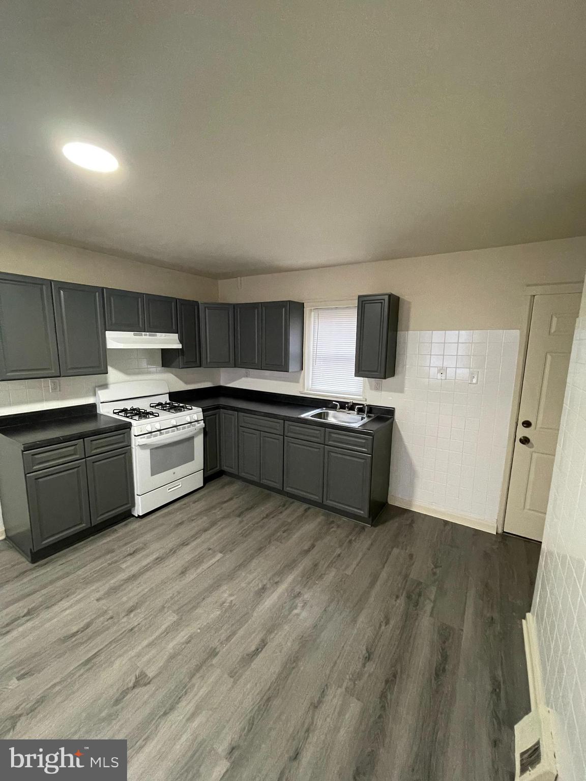 2441 North 5th Street Philadelphia, PA 19133 - Photo 3 of 18 a large kitchen with a stove top oven sink and cabinets
