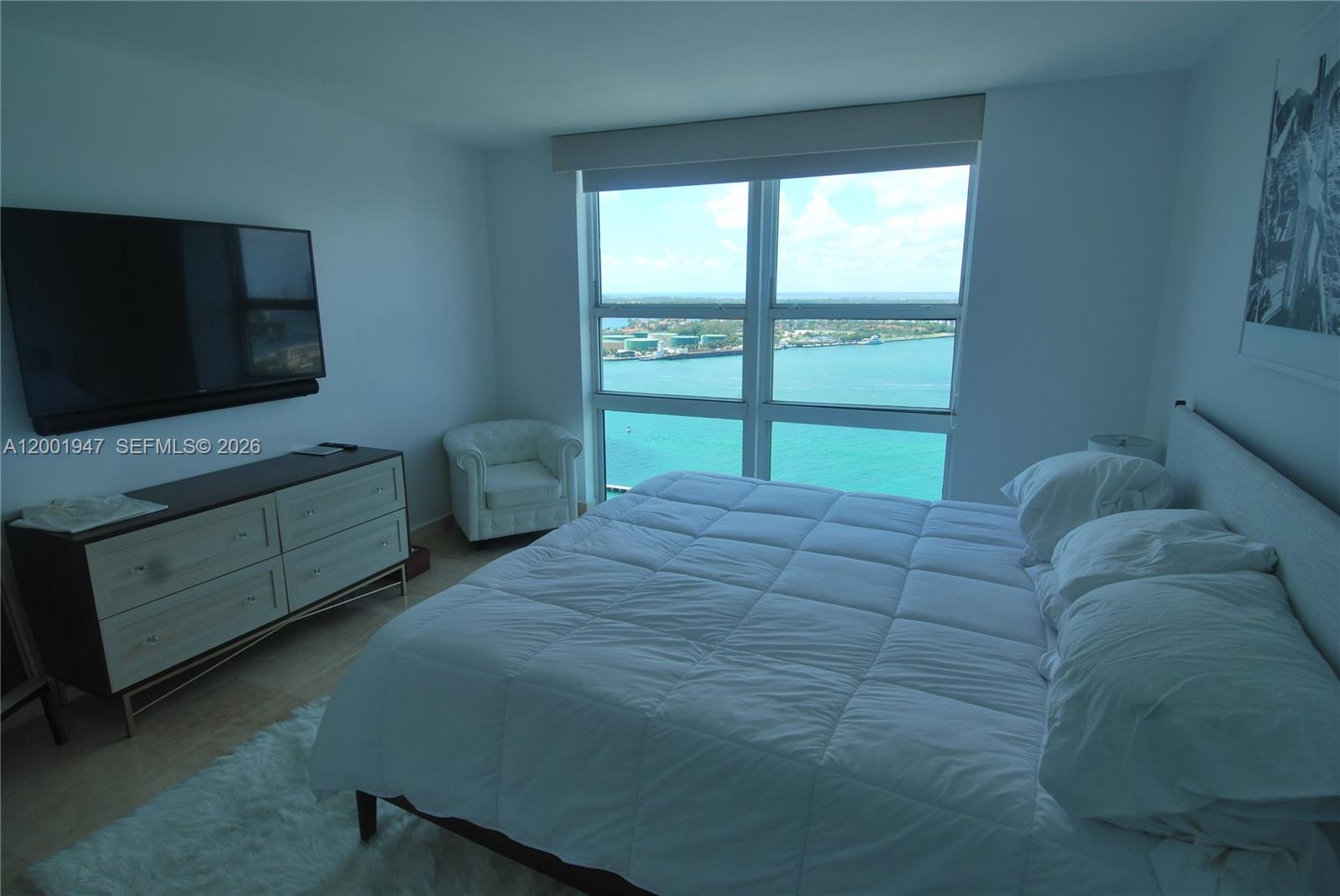 90 Alton Road, Unit 2606 Miami Beach, FL 33139 - Photo 3 of 13 a bedroom with a bed and a flat screen tv