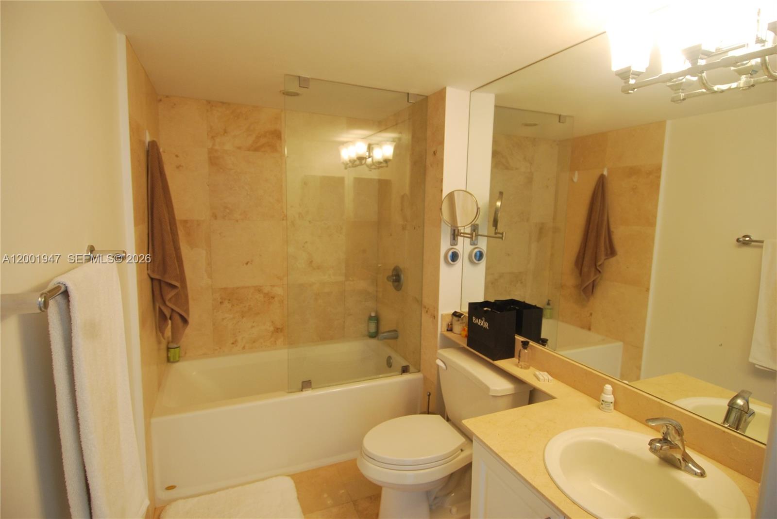 90 Alton Road, Unit 2606 Miami Beach, FL 33139 - Photo 4 of 13 a bathroom with a sink toilet and shower