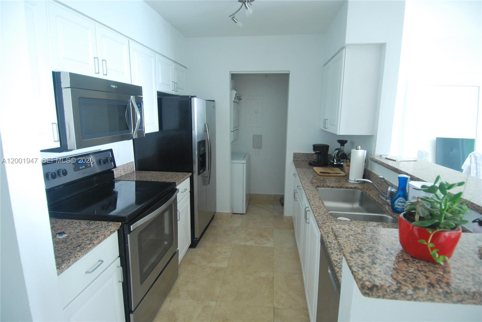 90 Alton Road, Unit 2606 Miami Beach, FL 33139 - Photo 5 of 13 a kitchen with stainless steel appliances granite countertop a sink and a refrigerator