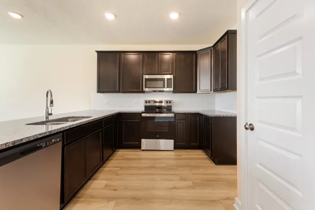a kitchen with granite countertop a refrigerator and a sink