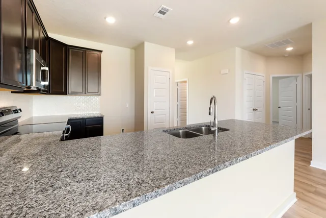 a bathroom with a granite countertop sink and a large mirror