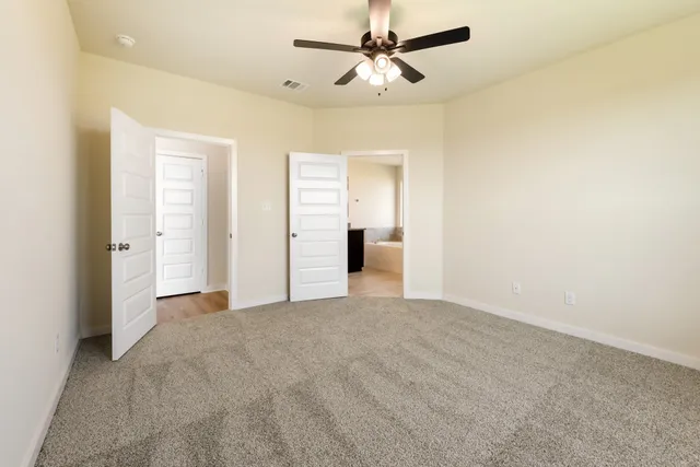 a view of a big room with closet and ceiling fan