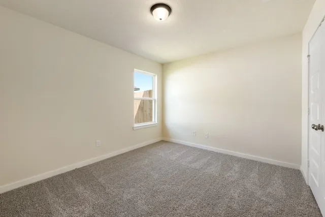 an empty room with windows and closet
