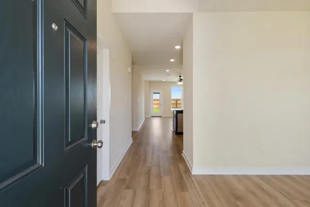 a view of a hallway with wooden floor