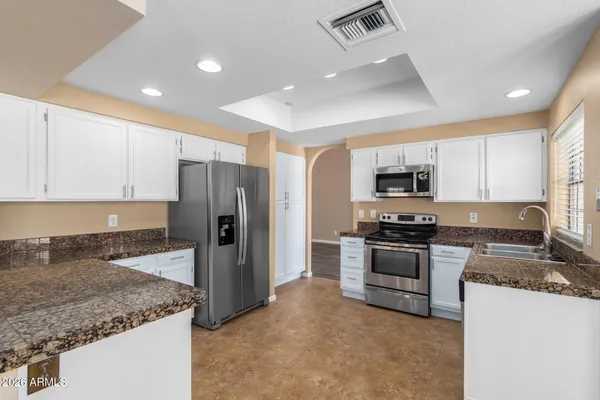 a kitchen with stainless steel appliances granite countertop a refrigerator and a sink
