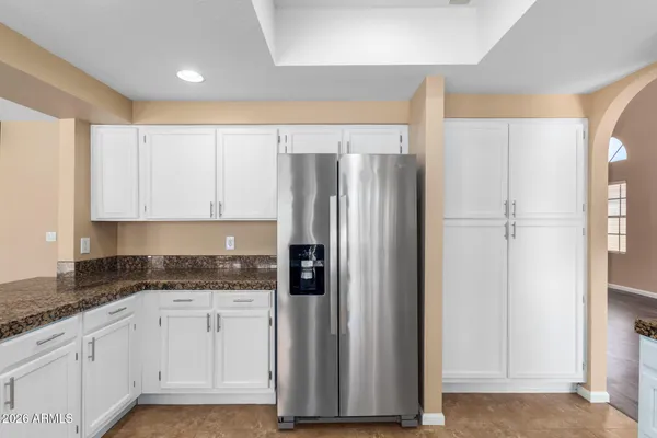 a kitchen with granite countertop a refrigerator sink and cabinets