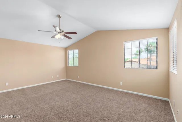 an empty room with a window and a ceiling fan