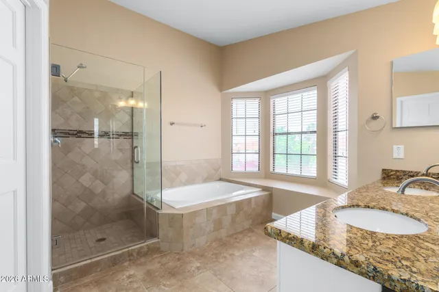 a bathroom with a granite countertop tub sink and shower