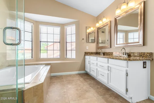 a spacious bathroom with a granite countertop tub sink and mirror