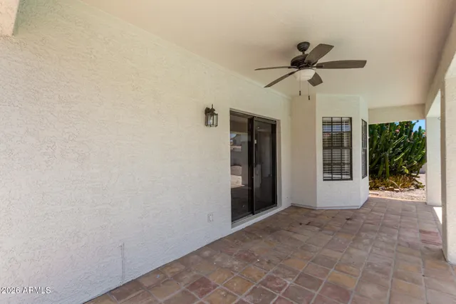 a view of empty room with ceiling fan and window