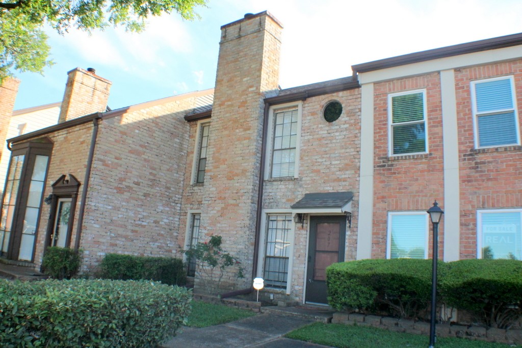 a brick building with a yard and a man seat