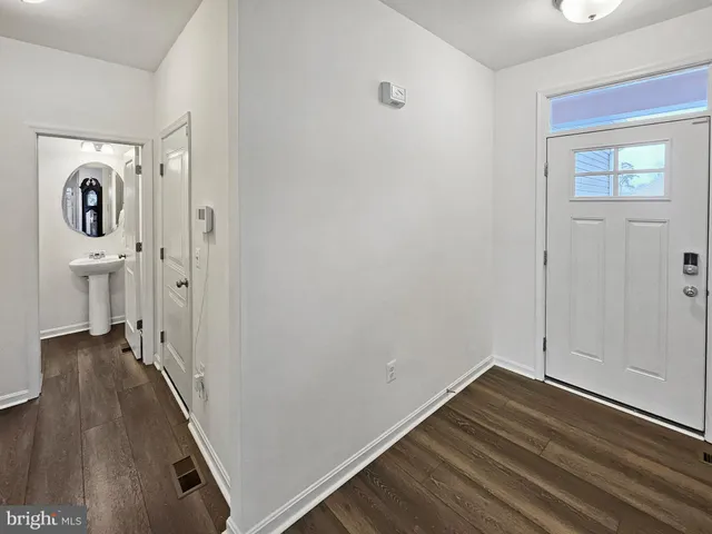 a view of a hallway with wooden floor and closet