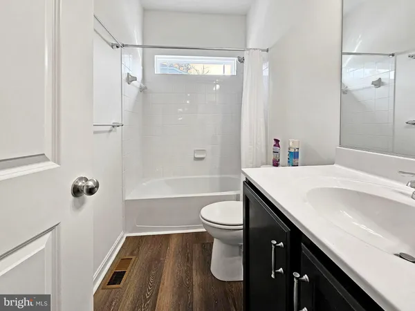 a bathroom with a sink a toilet a mirror and shower