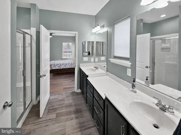 a en suite bathroom with a double vanity sink a mirror and shower