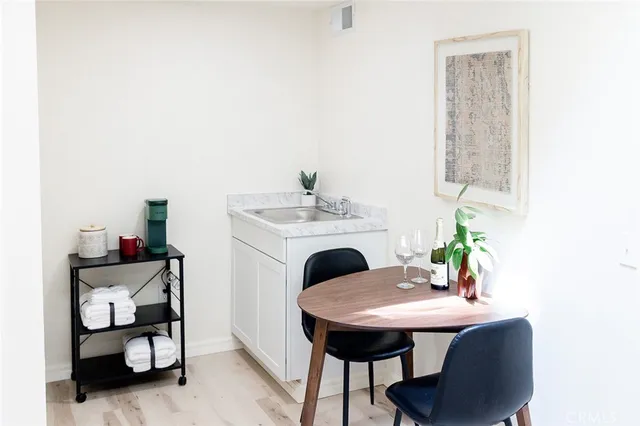 a view of a patio with table and chairs potted plants and large tree