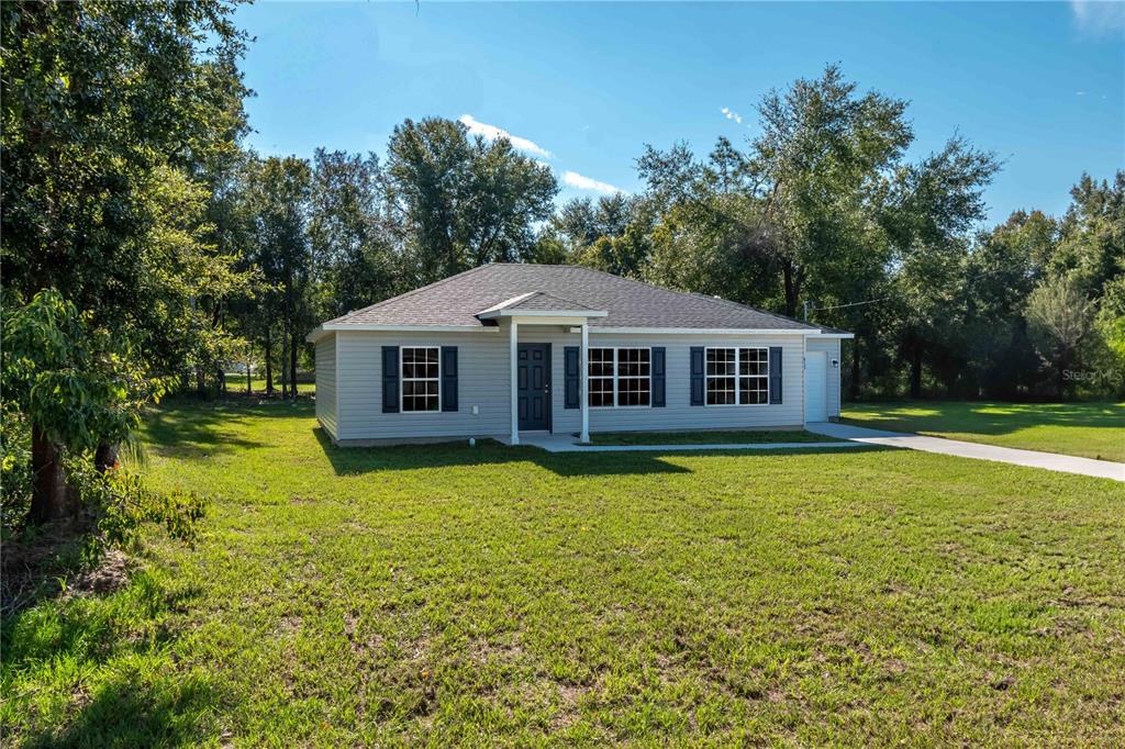 a front view of a house with yard and green space