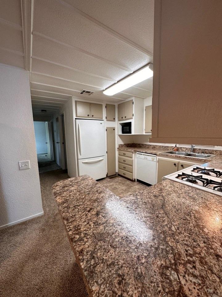 39678 Fresno Flats Road, Unit 39 Oakhurst, CA 93644 - Photo 11 of 34 a kitchen with a refrigerator and a stove