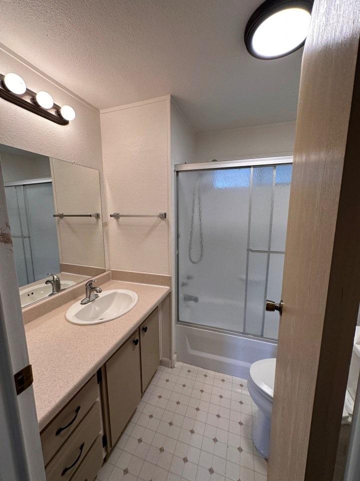 39678 Fresno Flats Road, Unit 39 Oakhurst, CA 93644 - Photo 17 of 34 a bathroom with a sink a toilet a shower and a mirror
