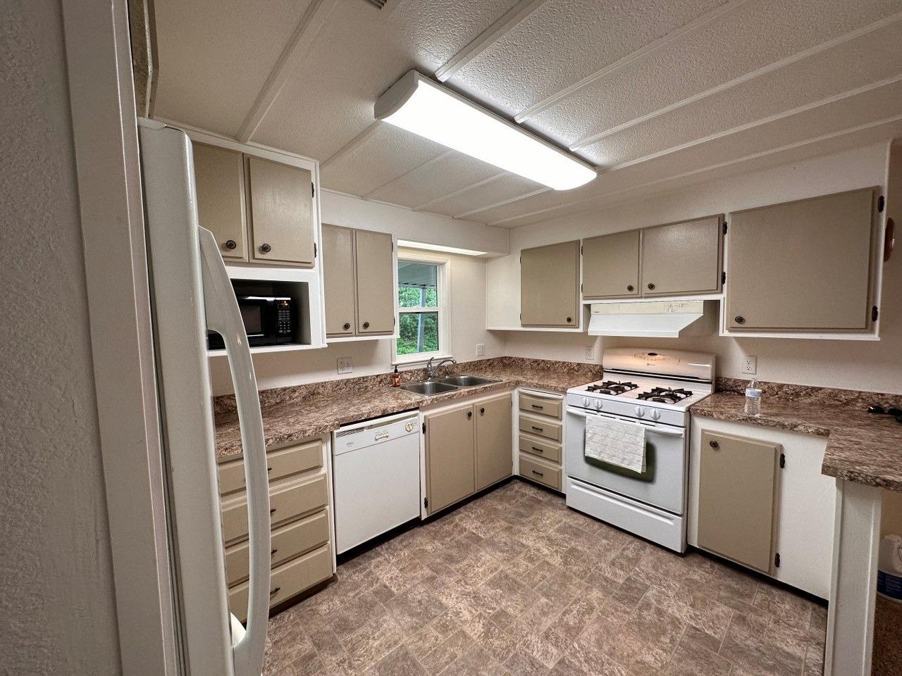 39678 Fresno Flats Road, Unit 39 Oakhurst, CA 93644 - Photo 8 of 34 a kitchen with stainless steel appliances granite countertop a stove sink and cabinets