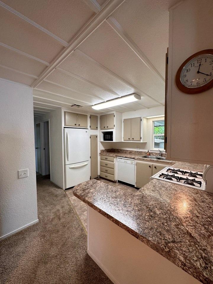 39678 Fresno Flats Road, Unit 39 Oakhurst, CA 93644 - Photo 9 of 34 a kitchen with a stove a sink and a refrigerator