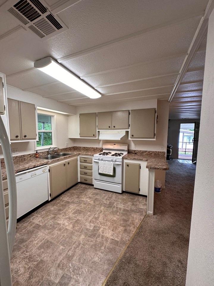 39678 Fresno Flats Road, Unit 39 Oakhurst, CA 93644 - Photo 10 of 34 a kitchen with a sink cabinets and stainless steel appliances