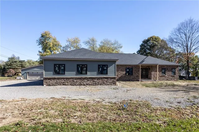 a front view of a house with a yard covered with snow