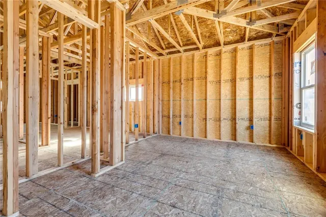 a view of an empty room with window and bathroom