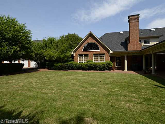8231 Stafford Mill Road Oak Ridge, NC 27310 - Photo 2 of 16 Exterior Back. Rear of home has the PERFECT spot for a future pool! Surrounded by a brick privacy fence and landscaping for privacy, this rear yard oasis boasts loads of entertaining areas fit for family outings!
