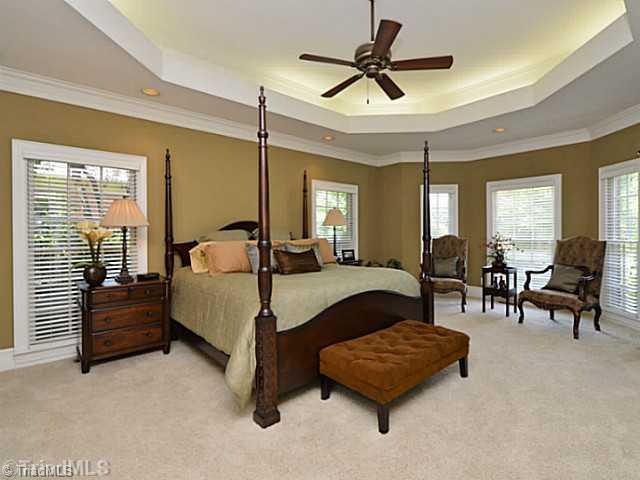 8231 Stafford Mill Road Oak Ridge, NC 27310 - Photo 12 of 16 Master Bedroom. Main level master boasts lighted trey ceiling, seating area and en-suite bath. His and hers walk in closets complete the master fit for a king.