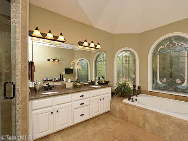 8231 Stafford Mill Road Oak Ridge, NC 27310 - Photo 13 of 16 Master Bath/Spa. Master bath includes walk in custom tile shower, granite countertops, his and hers walk in closets, tile floor, LARGE soaker tub and dual sinks. A separate makeup vanity (not shown) for the lady of the house as well!