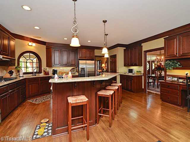 8231 Stafford Mill Road Oak Ridge, NC 27310 - Photo 6 of 16 Kitchen. Enormous kitchen features all SS Bosch appliances, granite countertops, work island with seating for at least five, and a separate work desk. Lots of space for the cook in your family.