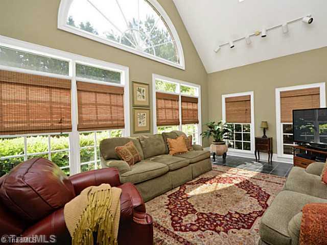 8231 Stafford Mill Road Oak Ridge, NC 27310 - Photo 10 of 16 Sunroom. Sunroom is bright an airy and features slate floor, vaulted ceilings and arched windows. Direct access to rear yard and den areas of the home.