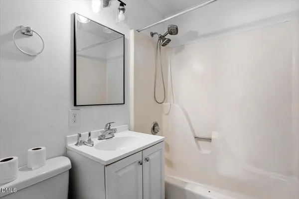 a bathroom with a granite countertop sink a toilet and a mirror