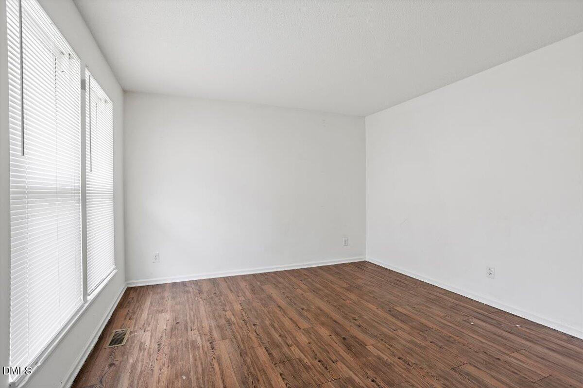 2000 Waters Drive Raleigh, NC 27610 - Photo 3 of 20 a view of an empty room with wooden floor and a window