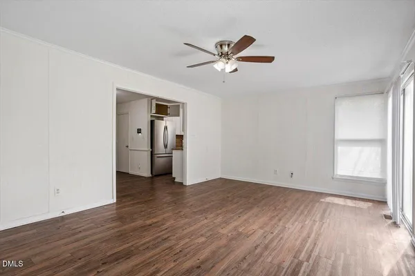 a view of empty room with wooden floor and window