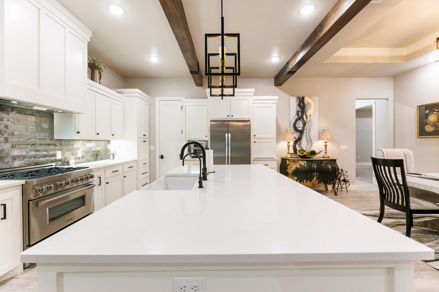 5310 112th Street Lubbock, TX 79424 - Photo 8 of 36 a kitchen with stainless steel appliances a dining table chairs stove and white cabinets