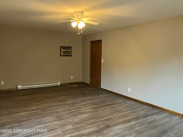a view of an empty room with a chandelier fan