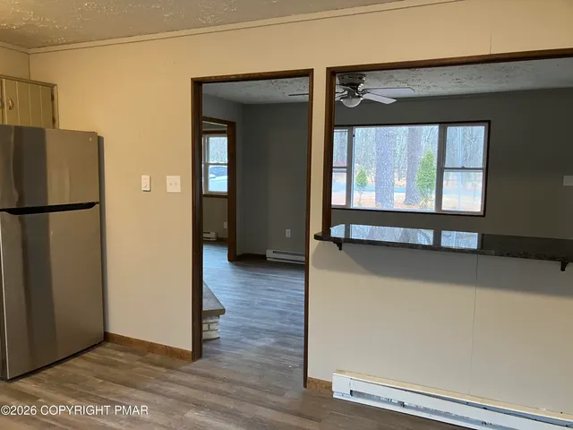 an empty room with wooden floor and a large window