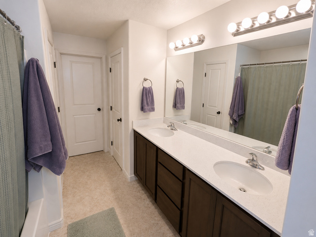 1687 South Windemere Road Santaquin, UT 84655 - Photo 12 of 27 Dual-sink bathroom vanity featuring white quartz countertops, dark wood cabinetry with ample storage, and chrome fixtures