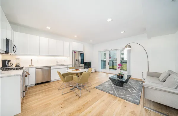 a living room with furniture and view of kitchen
