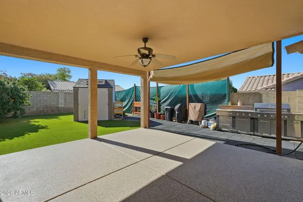 a view of a patio with a table and chairs under an umbrella