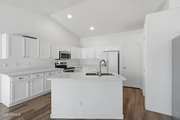 a kitchen with stainless steel appliances a sink a stove a microwave a sink a refrigerator and cabinets