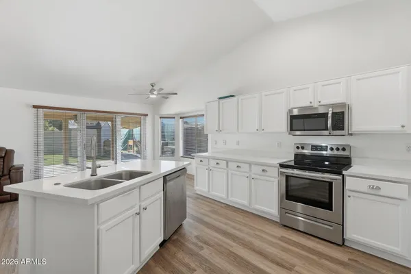 a kitchen with stainless steel appliances granite countertop a sink and a stove top oven