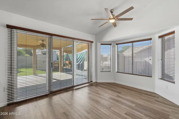 an empty room with wooden floor and windows